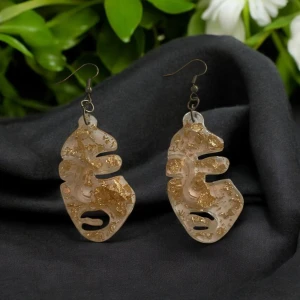 Unika örhängen med abstrakt design - Snygga örhängen med en unik abstrakt design i transparent material med guldglitter. Perfekta för att ge en konstnärlig touch till din stil. De har en krok för enkel användning.