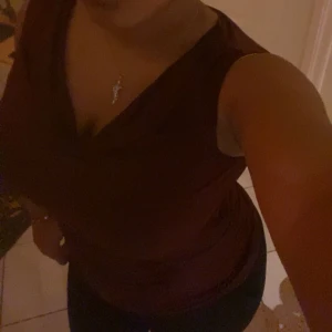 Vinröd topp - Snygg vinröd topp med en elegant drapering framtill. Perfekt för en kväll ute eller en speciell tillställning. Toppen har en smickrande passform och är tillverkad i ett mjukt material.