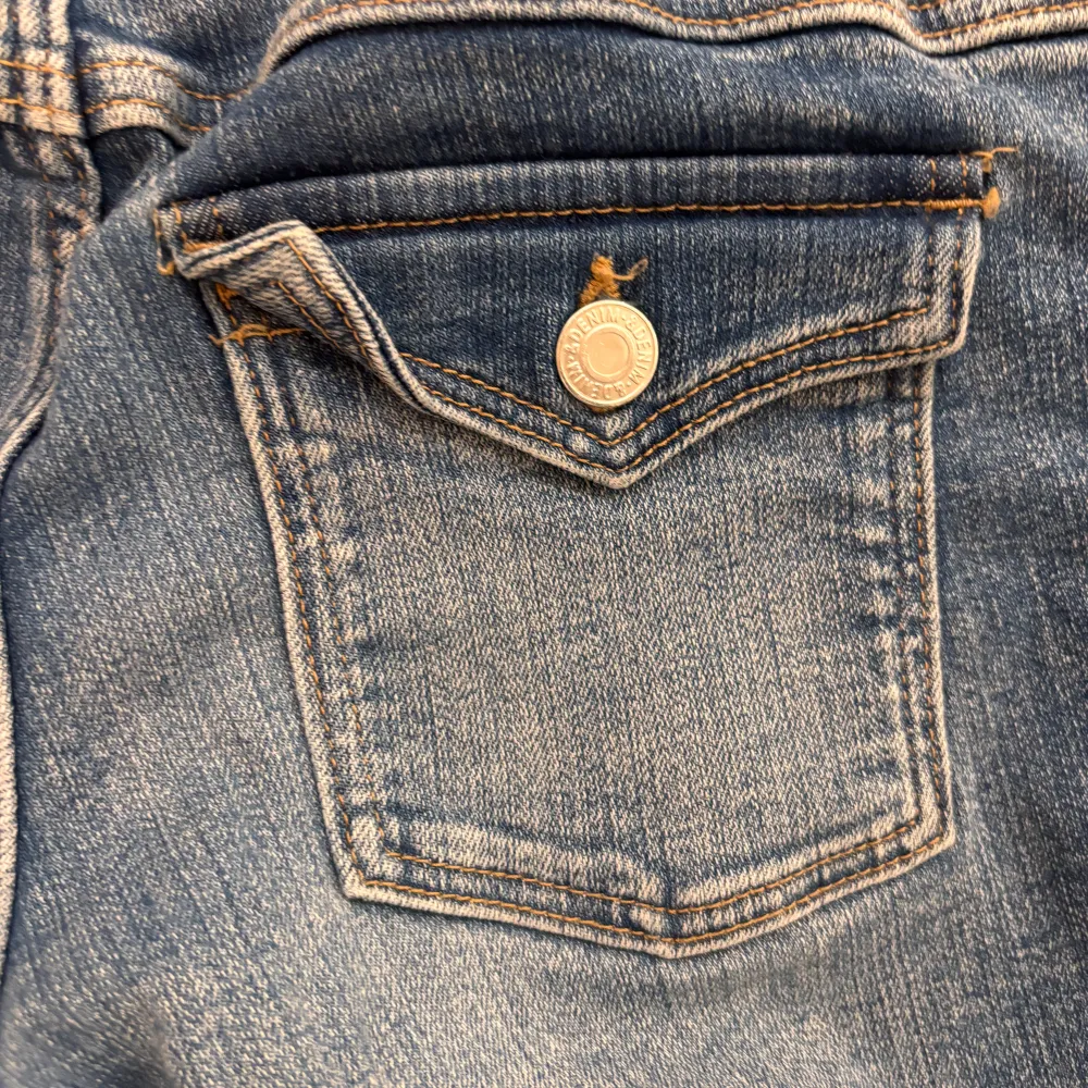 Snygga blå bootcut jeans från H&M med justerbar midja. De har en låg midja och klassisk femficksdesign. Perfekta för en avslappnad stil.. Farkut & Housut.