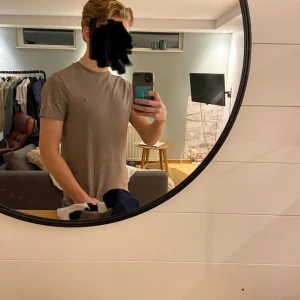 Beige t-shirt från Tommy Hilfiger - Säljer en stilren beige t-shirt från Tommy Hilfiger med deras ikoniska logga broderad på bröstet. Perfekt för en avslappnad look. T-shirten är kortärmad och gjord i mjuk bomull. Jag har S och fungerar bra på mig men Xs funkar även galant!