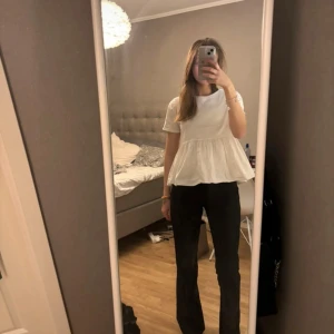 Vit blus med volangdetaljer - Säljer en söt vit topp med volanger från Zara i st s. Har ett hål men är absolut inget man tänker på💕