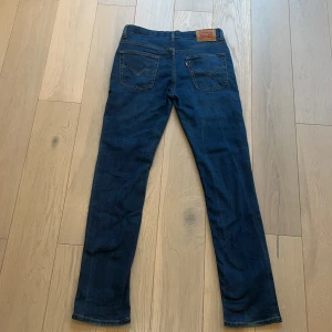 Levis 512 jeans - Snygga Levis 512 jeans i en klassisk blå färg. De har en slim passform och är tillverkade i slitstarkt denim. Perfekta för en avslappnad stil med en ikonisk Levis-lapp på baksidan. Jeansen är knappt använda och har inga skador eller slitage så hör av dig om du har funderingar👍