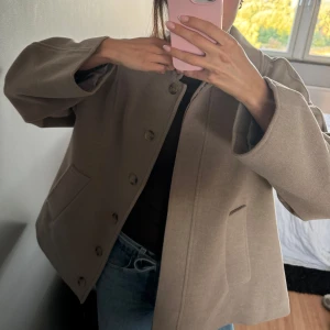 Kort Kappa NAKD - Kort beige kappa från NAKD, använt ett fåtal gånger 