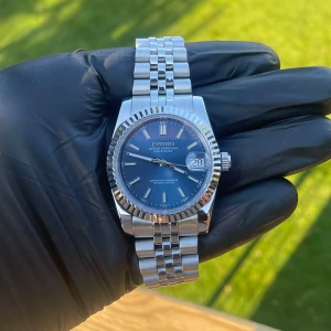 SEIKO  automatic - 36mm boett med en blå urtavla. Klockan har ett automatiskt urverk och är både snygg och stilig och kan användas i vilket tillfälle som helst.