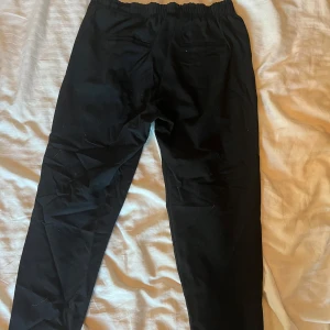 Svarta kostym byxor - Svarta kostym byxor med stretch vid midjan. De liknar lite ”mom jeans” i stilen men i kostym då.