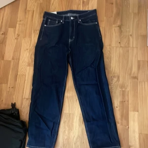 Mörkblå jeans från H&M - Säljer ett par mörkblå jeans från H&M i loose fit. De är i bra skick och perfekta för en avslappnad stil. Jeansen har klassiska fem fickor och en bekväm passform.