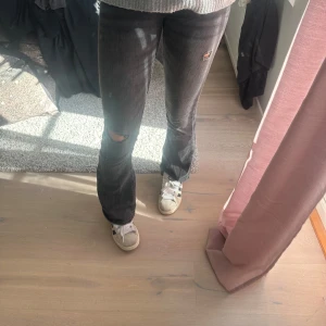 Bootcut jeans från zara - Hej! Säljer dessa bootcut jeans från Zara, de är mörkgråa/svarta med lite slitningar vid knäna och låren. Tror ej dessa säljs längre så därav vet jag inget nypris, använda men i fint skick💕