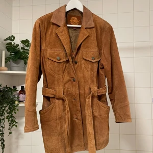 Mocka jacka äkta vintage - Säljer denna superfina äkta mockajacka som är vintage. Fodret är i princip orört ser det ut som. Även fickornas foder är helt och fräscht. Den är i toppenskick!! Som ny MEN vintage! Färgen är mest lik på bilden där jag har på mig jackan. 