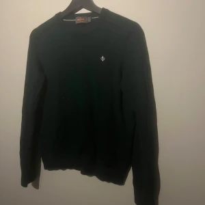 Morris tröja 100% merinoull  - Säljer en snygg mörkgrön tröja från Morris i 100% merinoull. Den är perfekt för höst och vinter med sin varma och mjuka känsla. Tröjan har en liten broderad detalj på bröstet och långa ärmar. Passar både till vardags och lite finare tillfällen.