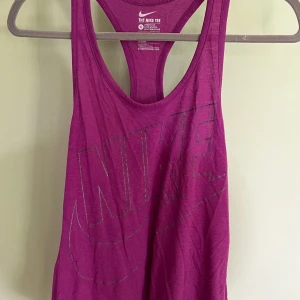 Lila träningslinne, Nike - Skick: Fint Material: 50% polyester, 25% bomull, 25% viskos   Säljer två svarta i samma modell.  