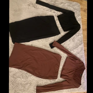 Två sett med kjol och topp - Det är två ribbade sett med slits på kjolarna. Ett i svart och ett i brunt. De bruna sättet är bara andvänt 1 gång och det svarta är andvänt lite fler, men är i väldigt bra skick.