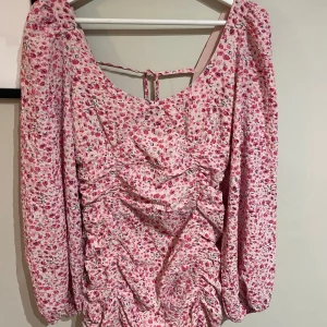 Rosa blommig kkäning - Jättefin sommar kläning med räfflat tyg och snygg uringning och knytning baktill!! 