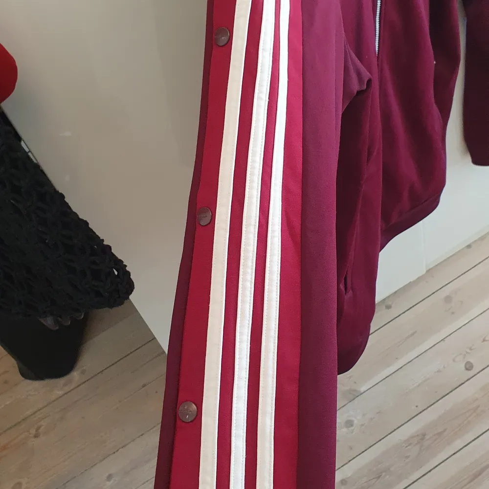 Track Jacket med knappar på ärmarna i klassisk adidas -stil. Mindre noppror vid fickorna, annars gott skick. . Tröjor & Koftor.