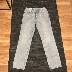 Ljusblå jeansbyxor med rak passform - Säljer ett par ljusblå jeansbyxor med rak passform. De har en klassisk design med fem fickor och knappgylf. Den är i storlek 28/32