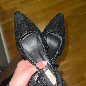 Svarta spetsiga klackskor - Eleganta svarta klackskor med spetsig tå och subtila detaljer från Nelly. Låg klack vilket gör dem bekväma att gå i. Nypris 549!