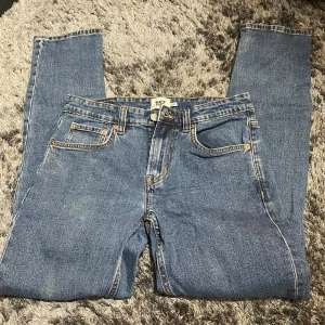 Blå jeansbyxor - Klassiska blå jeansbyxor med fem fickor och dragkedja. De har en normal passform och är perfekta för en avslappnad stil. Midjemått är W31 och längd L32.