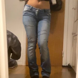 Blå jeans med broderade detaljer - Snygga blå jeans med låg midja och detaljer på bakfickorna. De har en straight leg- bootcut look. Säljer för jag önska de va bredare 😊👌🏽 ( pris kan diskuteras) ( är 164cm~62kg) de passar Xs-S 