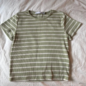 Grön och vit randig t-shirt - Grön och vit randig t-shirt från Lager 157. Den är kortärmad och har en ribbad struktur som ger en skön passform. 