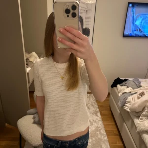 Vit stickad topp  - Säljer en söt vit stickad tröja från VILA i storlek XS. Tröjan har korta ärmar och är perfekt för sommaren