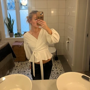 Vit omlottblus - Säljer en jättefin vit omlottblus med knytband i midja, de går att knyta både fram och bak💕super fint skick använd endast några gånger, skriv för fler bilder eller frågor!! 