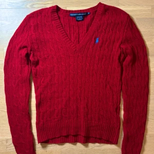 Ralph Lauren tröja  - Säljer en snygg röd stickad tröja från Ralph Lauren Sport i 100% lammull. Tröjan har en v-ringad design och ett blått broderat märke på bröstet. Nyligen ”deep cleaned” och aldrig bärts efter de. Pris går att diskutera !