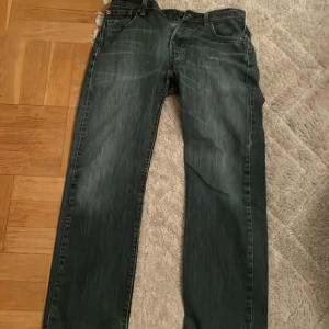 Levi's 501 jeans - Klassiska Levi's 501 jeans i blå denim med rak passform. De har en knappgylf och femficksdesign. Perfekta för en avslappnad stil. Jeansen har ett hål i bakfickan som är gjord så. Kontakta mig vid föndering.