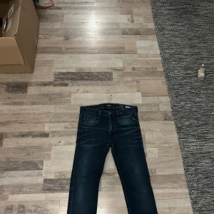 Mörkblå jeans från Replay - Snygga mörkblå jeans från Replay med klassisk femficksdesign och knappgylf. Perfekta för en avslappnad stil. De har en normal passform och är tillverkade i slitstarkt denim.