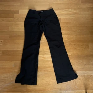 Svarta byxor från BikBok - Snygga svarta byxor från BikBok i storlek 34. De har en klassisk bootcut-stil och är perfekta för en stilren look. Byxorna har en dragkedja framtill och hällor för bälte.