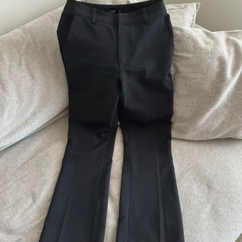 Snygga svarta kostymbyxor med hög midja och rak passform. Perfekta för en stilren look. Byxorna är från Bikbok i modellen ”Vilma petite”, passar perfekt om man är ca 160! . Farkut & Housut.