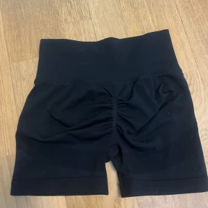 Svarta träningsshorts - Snygga svarta träningsshorts med hög midja och tight passform. Perfekta för gymmet eller löprundan. De är tillverkade i ett stretchigt material som ger bra stöd och komfort.