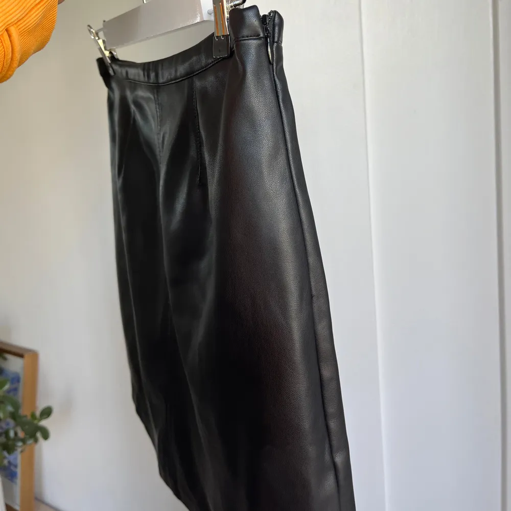 Snygg svart kjol i skinnimitation från Cubus. Klassisk, rak, tajt passform med ”osynlig” dragkedja. Normal i storlek XS/34. Hameet.