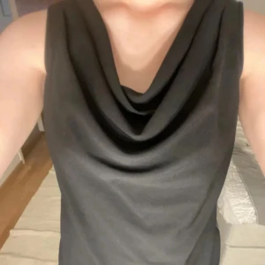 Svart ärmlös topp - Snygg svart ärmlös topp med draperad halsringning. Perfekt för en stilren look. Passar bra till både jeans och kjol. Köpte från Sellpy och de hade ingen lapp