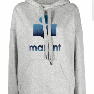 Grå hoodie från Isabel Marant - Säljer en snygg grå hoodie från Isabel Marant med blå logga på framsidan. Den har en klassisk känguruficka och justerbar huva med dragsko. Perfekt för en avslappnad stil. Normal i storleken, 36/S. Använt men mycket bra skick. Trycket är lite slitet som det lätt blir i tvätten. Syns på andra bilden. 