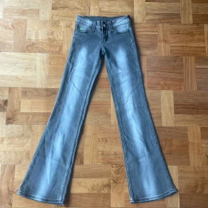 Grå bootcut jeans från Weekday  - Snygga grå bootcut jeans med en klassisk femficksdesign. De har en lätt tvättad look och är perfekta för en avslappnad stil. Passar bra till både sneakers och klackar.