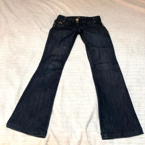 Mörkblå bootcut jeans från River Island - Snygga mörkblå jeans från River Island med bootcut-stil.  Midjemått 39cm ben längd 77cm