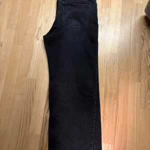 Svarta Galaxy Loose Straight Jeans från Weekday - Säljer ett par svarta Galaxy Loose Straight Jeans från Weekday. Storlek W:29 L:30 De har en avslappnad passform med raka ben och är tillverkade i ett hållbart material. Perfekta för en stilren look. Har använts ett fåtal gånger. Inga fläckar eller skador.  Pris kan diskuteras
