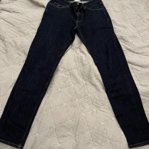 Mörkblå jeans från GANT - Snygga mörkblå jeans från GANT i slim fit. Perfekta för en stilren look med klassisk design och bekväm passform. Dessa jeans har en lågmidjad stil och är tillverkade i ett slitstarkt denimtyg.