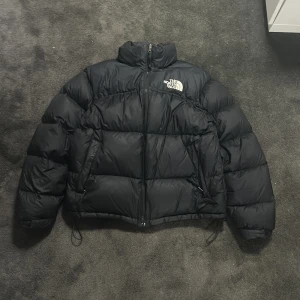 The North Face Nuptse - Säljer min svarta nuptse i strl L då den inte använts på 2 år. Använd en vinter säsong och i perfekt skick utan några laglingar osv. Skriv gärna vid intresse och för fler bilder, pris ej hugget i sten vid skön affär!