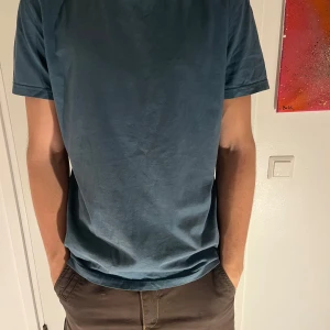 Blå t-shirt från Hampton Republic - Säljer en stilren blå t-shirt från Hampton Republic. Den har en klassisk design med korta ärmar och rund hals. Perfekt för en avslappnad look.