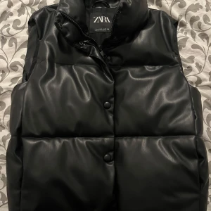 Svart dunväst från Zara - Säljer den här snygga svart västen från Zara. Inga defekter och använd fåtal gånger💘