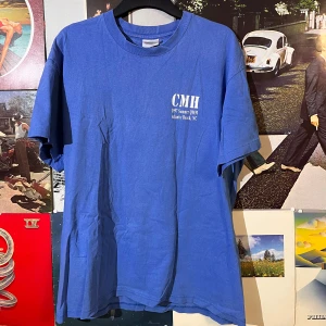 Blå 1997 vintage t-shirt från Hanes - Säljer en blå t-shirt från Hanes med tryck på både fram- och baksida. På framsidan står det 'CMH 1997 Summer QMM Atlantic Beach, NC' och på baksidan 'DIDN'T Get Blown Away This Year'. Inga defekter! Storlek är mellan M-L Dm vid frågor
