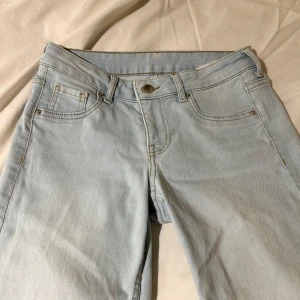 Ljusblå bootcut jeans - Säljer ett par ljusblå bootcut jeans i mycket bra skick. De är lågmidjade och har en klassisk design. Perfekta för både vardag och fest!
