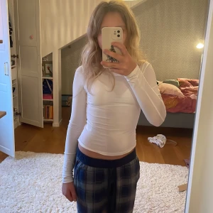 Vit långärmad topp - Säljer en vit långärmad topp i tight passform. Perfekt för lager-på-lager eller att bära som den är. Toppen är enkel och stilren, vilket gör den lätt att matcha med olika outfits. Passar bra till både vardag och fest.