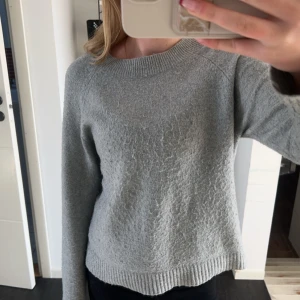 Grå stickad tröja - Säljer en grå stickad tröja med lång ärm. Den är supermysig och perfekt för kyliga dagar. Tyvärr finns det ett litet hål på ena ärmen, men det går säkert att fixa. Passar bra till både jeans och kjol. Perfekt för höst och vinter!