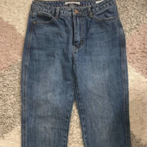 Blå jeansbyxor - Säljer ett par klassiska blå jeansbyxor med rak passform. De har en traditionell femficksdesign och knappgylf. Perfekta för en avslappnad stil.
