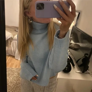 Ljusblå stickad polotröja - Säljer en supermysig ljusblå stickad polotröja. Den har en hög krage och långa ärmar med ribbade muddar. Köpt på Gina Young men sitter som en s