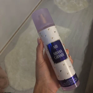 Ari Body Mist från Ariana Grande - Fräsch body mist från Ariana Grande med en söt och fruktig doft. Flaskan är lila med ett elegant mönster av små trianglar och har en praktisk sprayfunktion. Perfekt för att fräscha upp under dagen. Knappt använd
