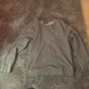 Grå tröja från J.Lindeberg - Säljer en stilren grå tröja från J.Lindeberg Storlek XL men sitter som L eller M ganska oanvänd