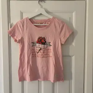 Säljer en söt rosa t-shirt från Odd Molly med ett tryck framtill. T-shirten har korta ärmar och en rund halsringning. Perfekt för en avslappnad stil. 🌸