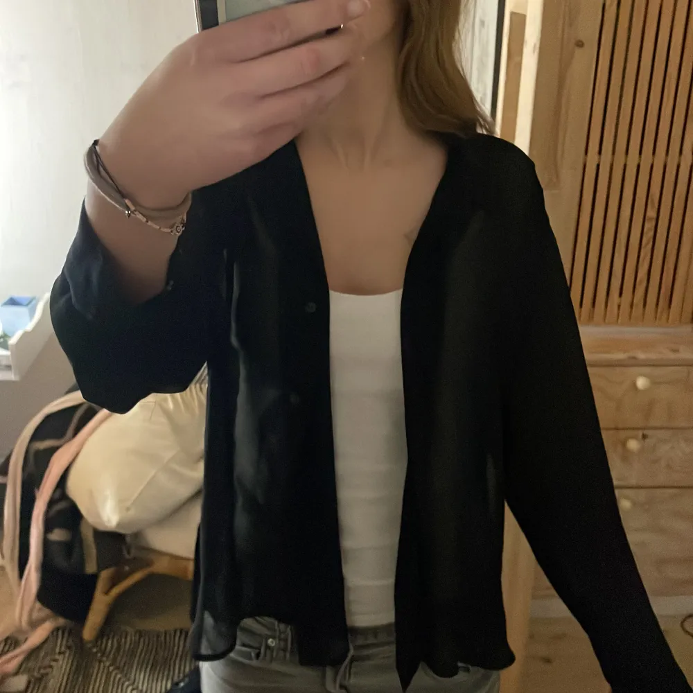Säljer en stilren svart skjorta/blus från Weekday i storlek Small/X-Small. Den är lätt, luftig och genomskinlig. Passar både till vardags och festliga tillfällen.. Paidat.
